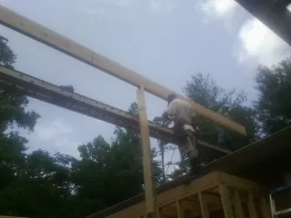 Carpenter setting a ridge beam over a new addition frame — Ice Dam Removal by Roofing Brothers in Abingdon